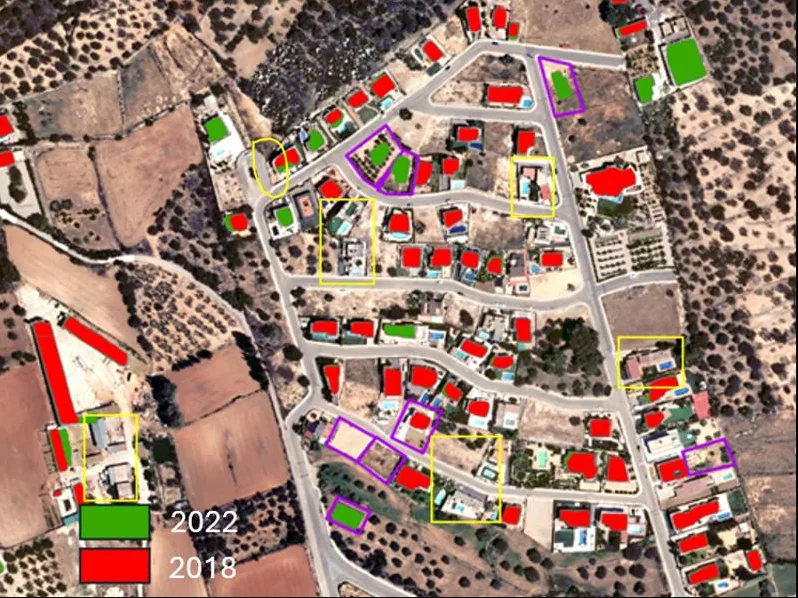 Aerial image of a neighborhood with building footprints colored red for 2018 and green for 2022, and changed sites outlined
